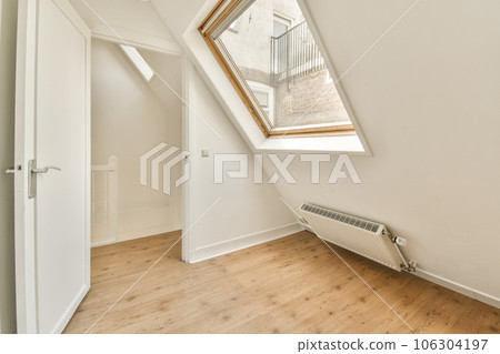 an attic room with wood flooring and skylights on the side of the window above it is a white rad 106304197