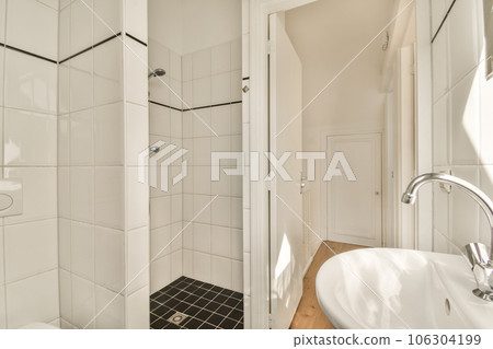 a bathroom with white walls and black tile on the floor, along with a toilet in the corner of the room a bathroom with white walls and black tile on the floor, along with a toilet in the corner of the room 106304199