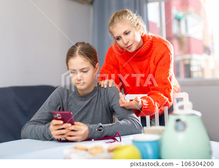 Girl sitting with phone, ignoring mother Girl sitting with phone, ignoring mother 106304200