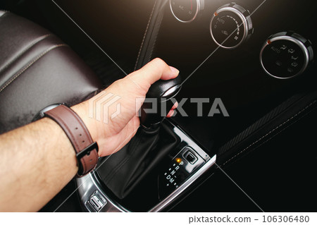 Driver hand holding gear lever of automatic transmission and hand moves the gear lever in the car 106306480