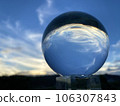 The evening sky reflected in a glass ball 106307843