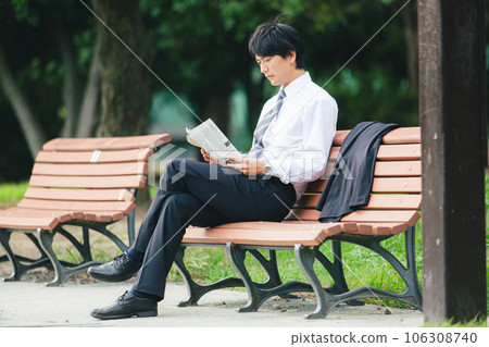 man reading a newspaper in the park man reading a newspaper in the park 106308740