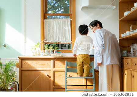 3 year old boy playing house in the kitchen 3 year old boy playing house in the kitchen 106308931