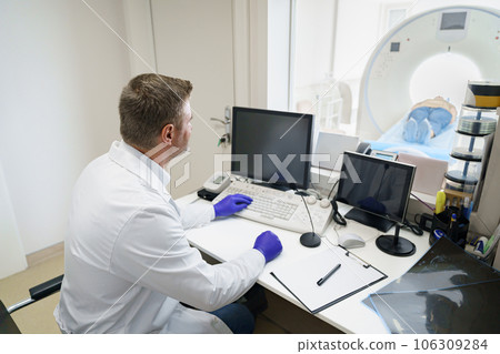 Doctor radiologist controls MRI or CT or PET Scan with female patient undergoing procedure Doctor radiologist controls MRI or CT or PET Scan with female patient undergoing procedure 106309284