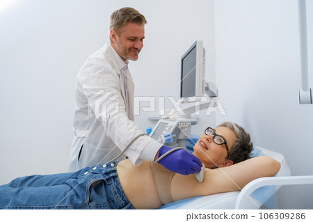 Mature woman has a ultrasound lymph nodes in area under the armpits in medical clinic Mature woman has a ultrasound lymph nodes in area under the armpits in medical clinic 106309286