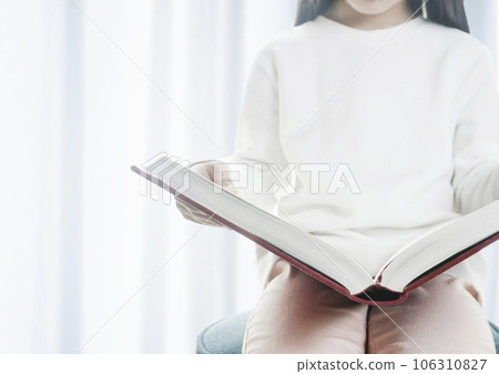 child reading a thick book 106310827