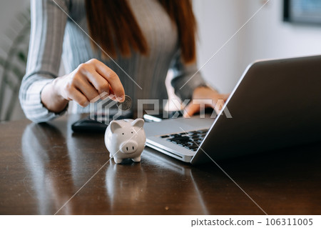 Women are putting coins in a piggy bank for a business that grows for profit and saving money for the future. planning for retirement concept. Women are putting coins in a piggy bank for a business that grows for profit and saving money for the future. planning for retirement concept. 106311005