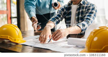 Engineer teams meeting working together wear worker helmets hardhat on construction site in modern city.Asian industry professional team Engineer teams meeting working together wear worker helmets hardhat on construction site in modern city.Asian industry professional team 106311160