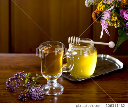 Still life from medicinal herbs, honey, herbal tea on a wooden background Still life from medicinal herbs, honey, herbal tea on a wooden background 106311482