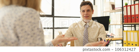 A businessman in office is listening to woman colleague A businessman in office is listening to woman colleague 106312427