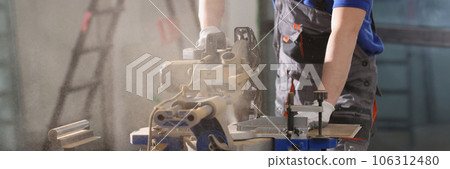 A happy worker works behind a cutting machine, close-up A happy worker works behind a cutting machine, close-up 106312480