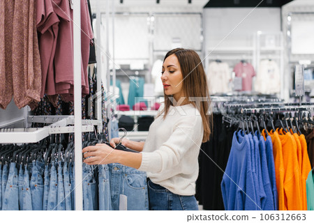 European woman in a clothing store chooses new jeans for herself 106312663