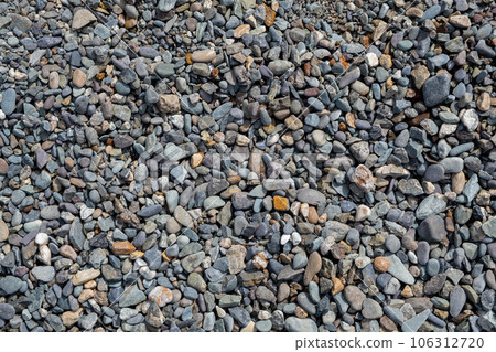 The stones were laid on the ground in the garden as a background. Background blur. Pebble stones background. Crushed stone on the seashore. Selective focus on object. The stones were laid on the ground in the garden as a background. Background blur. Pebble stones background. Crushed stone on the seashore. Selective focus on object. 106312720