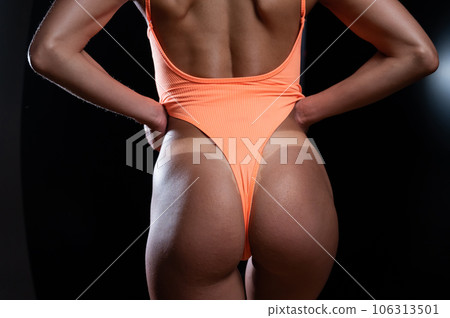 A faceless woman in an orange swimsuit demonstrates the result of an instant tan A faceless woman in an orange swimsuit demonstrates the result of an instant tan 106313501