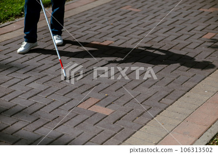A faceless blind woman walks down the street with a cane. A faceless blind woman walks down the street with a cane. 106313502