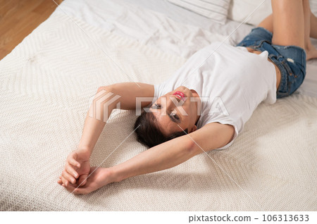 Caucasian transgender man lies on bed. Gay posing in the bedroom. 106313633