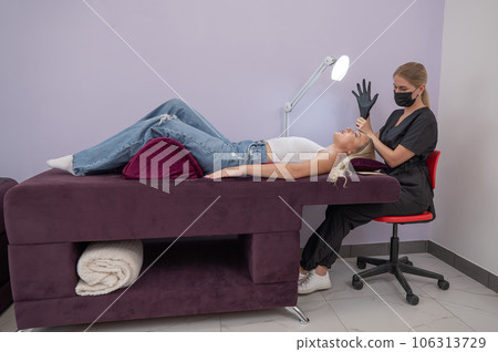 Caucasian woman on eyelash extension procedure. Caucasian woman on eyelash extension procedure. 106313729