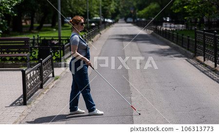 Blind pregnant woman crosses the street with the help of a tactile cane. Blind pregnant woman crosses the street with the help of a tactile cane. 106313773