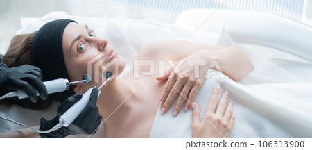 Young caucasian woman on microcurrent therapy procedure. Beautician's office. 106313900