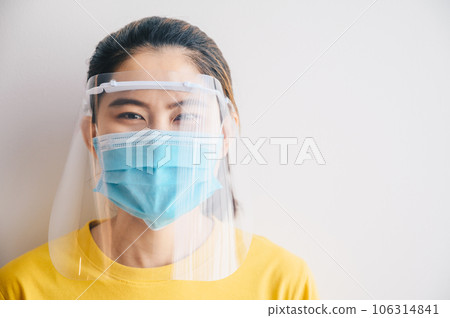 Asian woman smiling under mask and face shield for prevent and protection covid-19 virus disease. Conceptual of new normal lifestyle after Covid-19 pandemic outbreak. 106314841