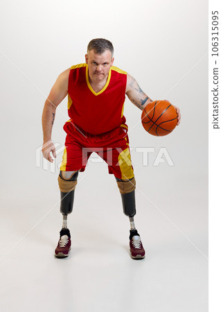 Attractive, confident man with prosthetic leg disability with orange basketball ball in motion. Inclusive sport for people with disabilities. 106315095