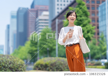 Young business woman in office casual commuting to office district 106315326