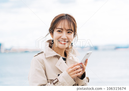 A young woman with a smartphone outdoors A young woman with a smartphone outdoors 106315674