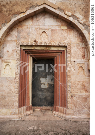 Carving details on the inner wall of Dai Ka Mahal, a tomb of a lady, standing on a lofty basement having rooms with arched openings for the keepers of the tomb located in Mandu, Madhya Pradesh, India 106316061