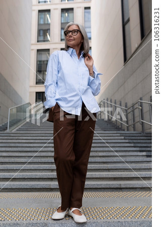 business portrait of a successful senior woman with gray hair and glasses dressed in office stylish business portrait of a successful senior woman with gray hair and glasses dressed in office stylish 106316231