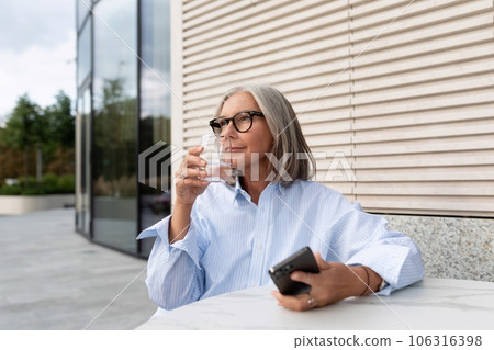 successful free gray-haired business grandmother dressed in a stylish shirt is waiting for a meeting 106316398