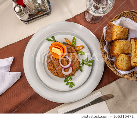 Beef tartare dish with onion rings 106316471