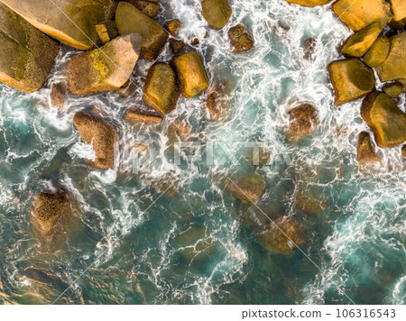Waves crashing on seashore rocks,Top view sea surface waves background Waves crashing on seashore rocks,Top view sea surface waves background 106316543
