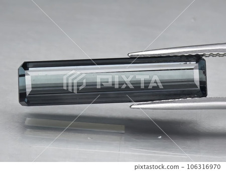 Natural gem blue tourmaline on a gray background 106316970