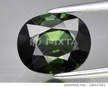 Natural gemstone green tourmaline on gray background 106317001
