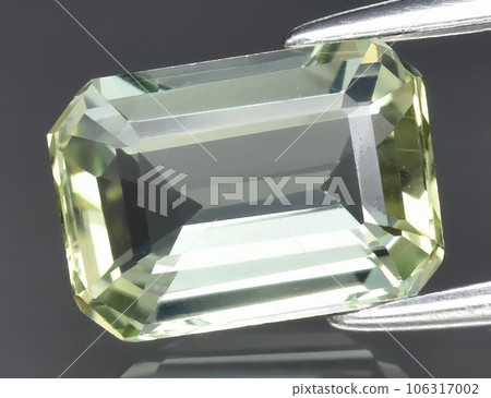 Natural gemstone green tourmaline on gray background 106317002