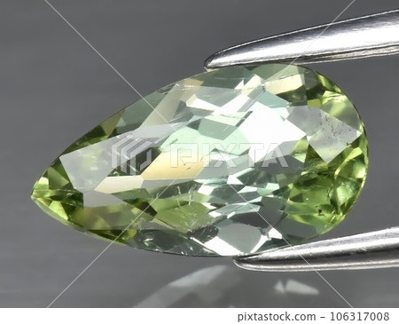 Natural gemstone green tourmaline on gray background Natural gemstone green tourmaline on gray background 106317008