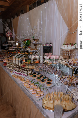 Sweet cakes at a wedding banquet. Catering, sweet festive buffet. Candy bar 106317031