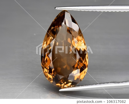Natural gemstone orange topaz on a gray background. Imperial topaz, champagne topaz Natural gemstone orange topaz on a gray background. Imperial topaz, champagne topaz 106317082