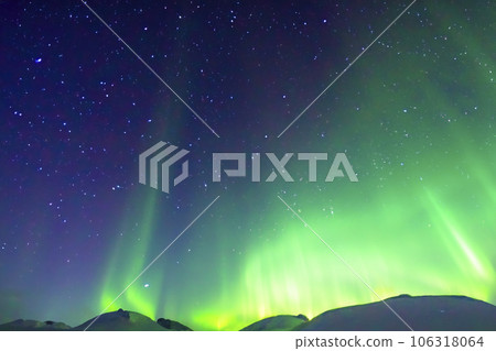 Northern Lights. Aurora. Iceland. Moment of greatest activity. Northern lights over the sea, snowy mountains. Starry sky. Winter landscape with aurora. Tree silhouette. Villages silhouette. 2023. Northern Lights. Aurora. Iceland. Moment of greatest activity. Northern lights over the sea, snowy mountains. Starry sky. Winter landscape with aurora. Tree silhouette. Villages silhouette. 2023. 106318064
