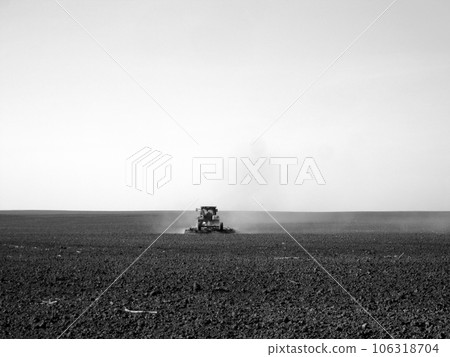 Plowed field by tractor in black soil on open countryside nature Plowed field by tractor in black soil on open countryside nature 106318704