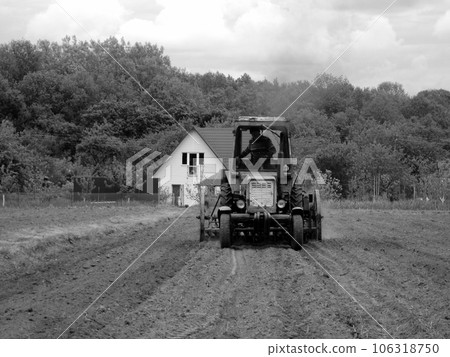 Plowed field by tractor in black soil on open countryside nature 106318750