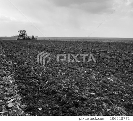 Plowed field by tractor in black soil on open countryside nature Plowed field by tractor in black soil on open countryside nature 106318771