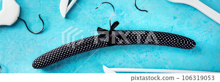 Fashion collection panorama. Black satin hangers for delicate clothes Fashion collection panorama. Black satin hangers for delicate clothes 106319053