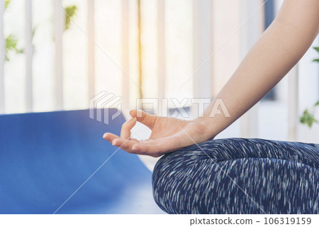 Yoga fitness lifestyle healthy woman relaxation doing a meditation. Yoga meditate outdoor with zen on sitting position. Yoga woman workout in sportswear sit on yoga mat home fitness workout exercise 106319159