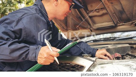 Close up Car Mechanic man hands repairing car auto repair shop. Man hands fixing machinery vehicle mechanical service. open vehicle hood checking up auto mobile. Vehicle Car maintenance engineer. 106319170