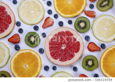 background of blueberries, strawberries, lemon, orange, grapefruit and kiwi slices on a white background - the concept of a healthy diet. Summer bright food fruit background, food design. background of blueberries, strawberries, lemon, orange, grapefruit and kiwi slices on a white background - the concept of a healthy diet. Summer bright food fruit background, food design. 106319794
