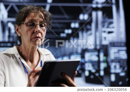 Elderly IT programmer using tablet to assess server cybersecurity dangers arising due to unsecured network connections. Supervisor ensuring high tech facility is impenetrable by ddos attacks Elderly IT programmer using tablet to assess server cybersecurity dangers arising due to unsecured network connections. Supervisor ensuring high tech facility is impenetrable by ddos attacks 106320056