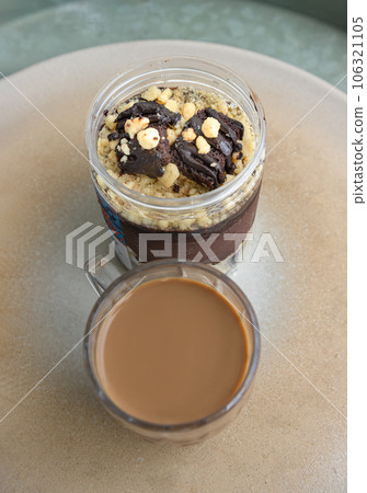 Good morning with Crumble dark chocolate brownie served with Coffee in glass cup on Ceramic tray. Good morning with Crumble dark chocolate brownie served with Coffee in glass cup on Ceramic tray. 106321105