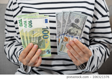 Euros and dollars in the hands of a person, different currencies Euros and dollars in the hands of a person, different currencies 106321376