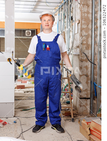 Professional builder handyman working with angle drive grinder indoors Professional builder handyman working with angle drive grinder indoors 106322472